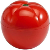 Tomato-shaped plastic vegetable saver food storage container on white background